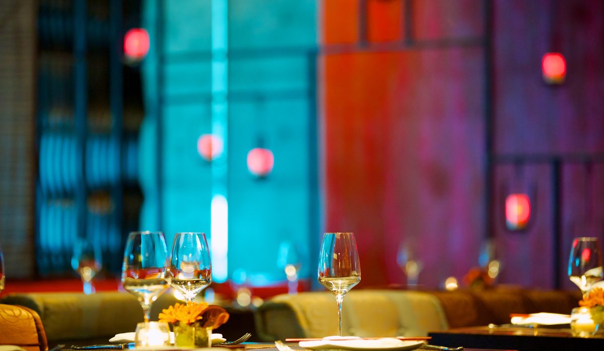 Empty dinner table in an upscale restaurant, set with full wine glasses